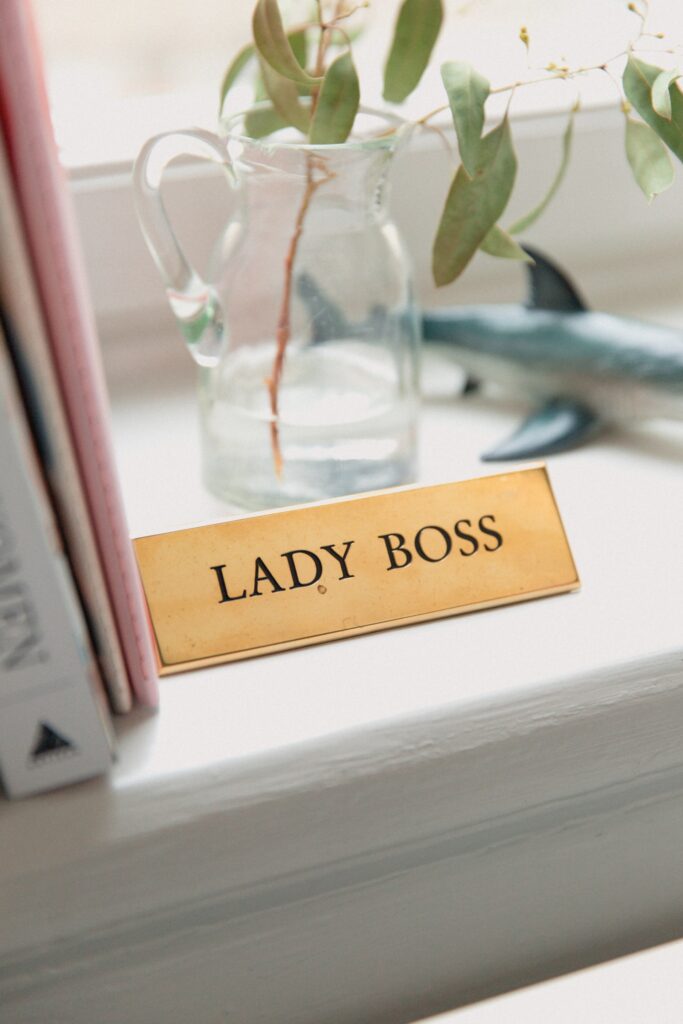 
Some books and a planter with a sign which says 'Lady Boss'