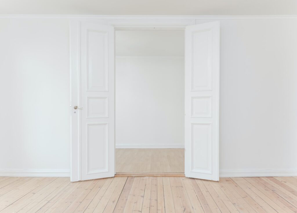 A white door opened to the empty space in the room